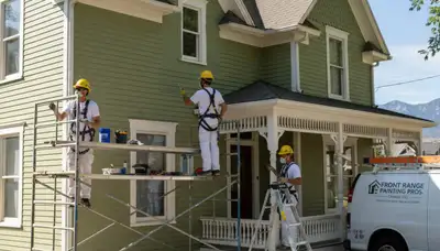 Painter working on a home exterior in Loveland, CO for professional residential painting services